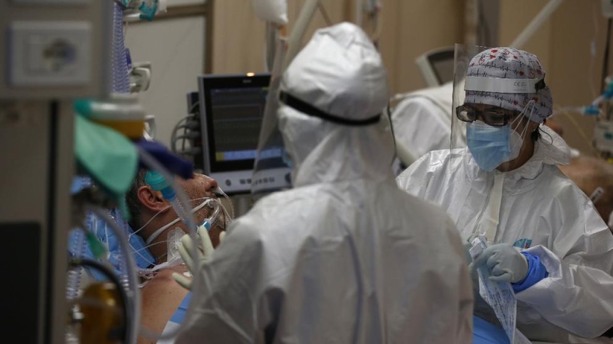 Personal sanitari amb equips de protecció atenen un pacient a l’UCI.