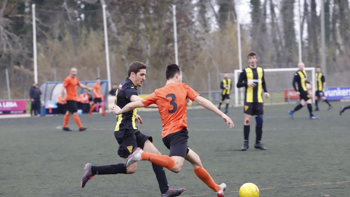 Un jugador del Pinyana intenta controlar el balón ante un defensor del Pardinyes.