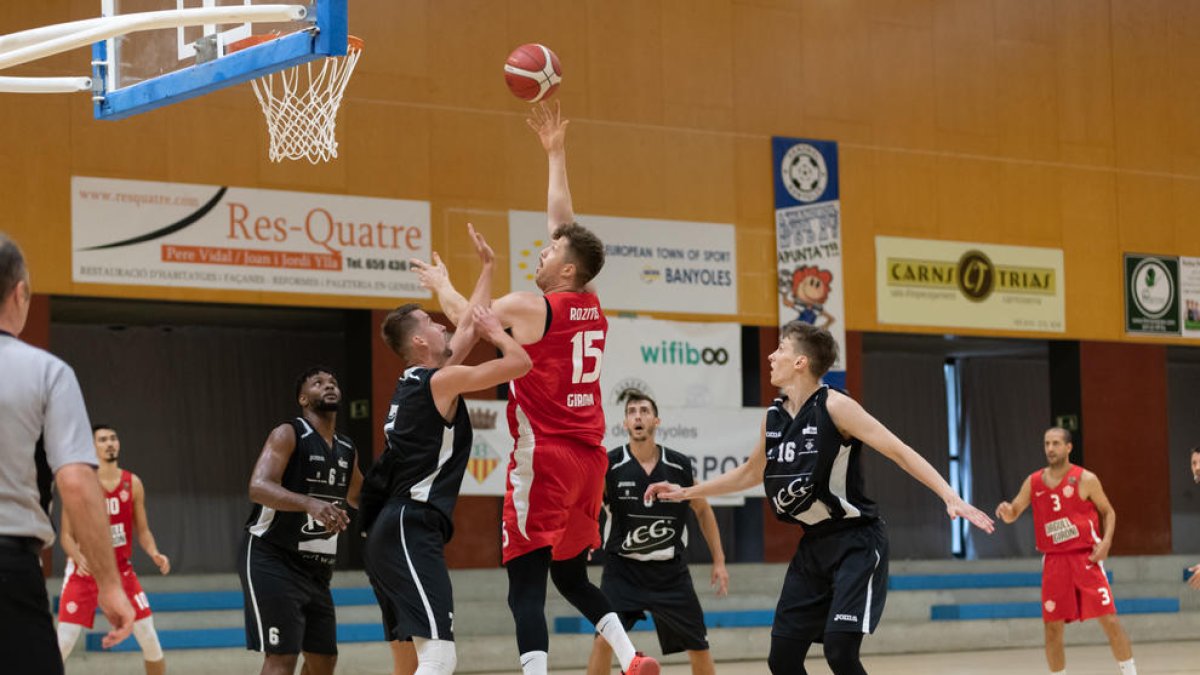 Davis Rozitis, exjugador del Força Lleida, llança a cistella davant de Mirza Bulic.