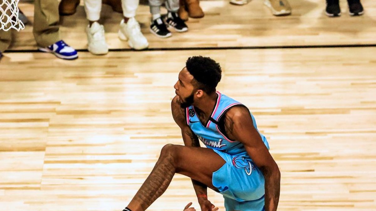 Derrick Jones supera a dos voluntarios en uno de sus mates.