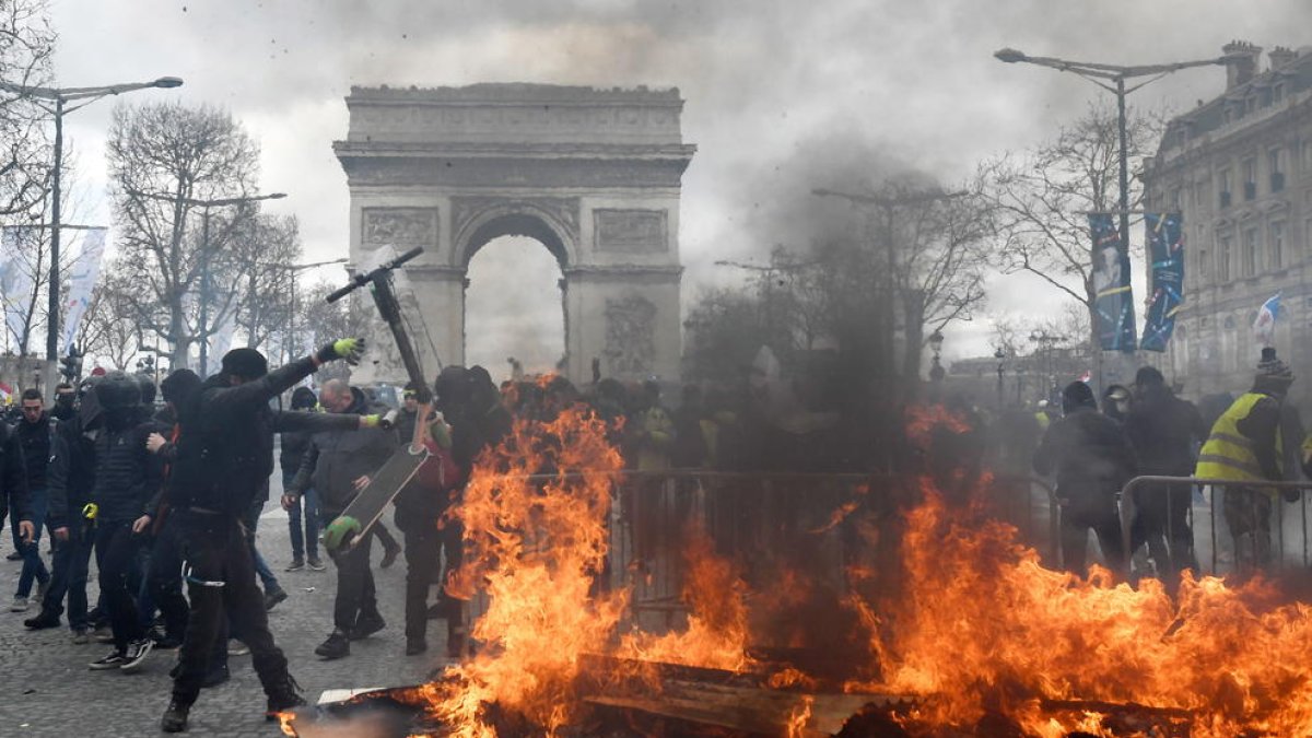 Els Armilles Grogues munten barricades i fogueres davant de la policia als Camps Elisis.
