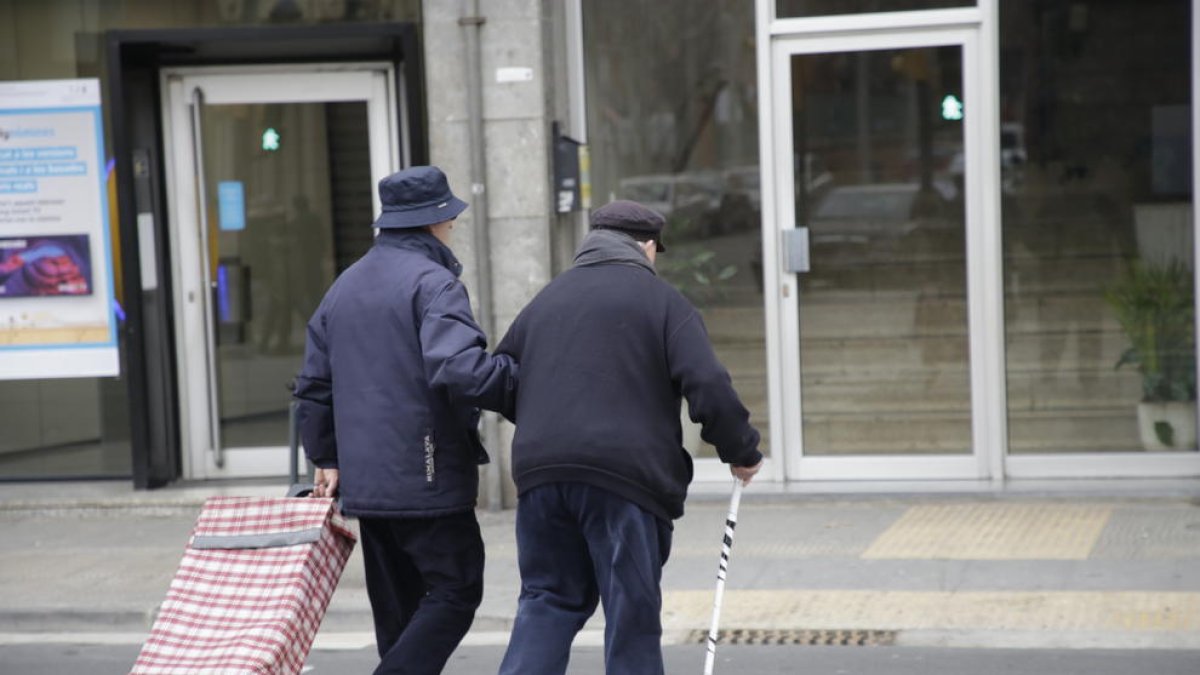 Dos ancianos cruzan un paso de peatones en el barrio de Balàfia.
