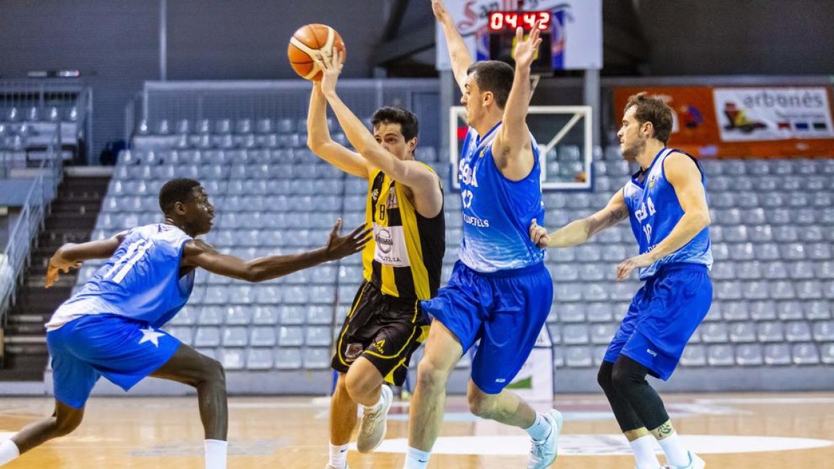 Un jugador del Pardinyes, con el balón ante la oposición de tres del Castelldefels, ayer en el partido.