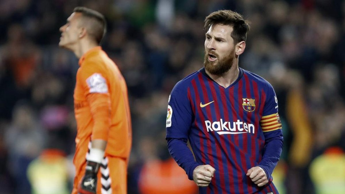 Leo Messi celebra el gol que va anotar de penal i que va servir per sentenciar el partit, amb l’exporter blaugrana al fons lamentant-se malgrat ser el millor del seu equip.