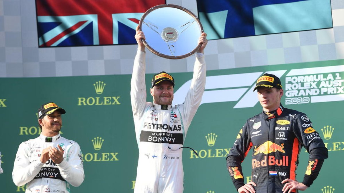 Valtteri Bottas levanta el trofeo como ganador de la carrera, escoltado en el podio por Hamilton y Verstappen.