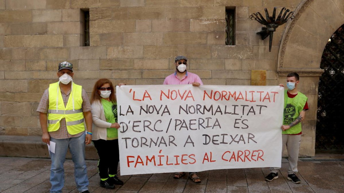 Dues de les persones que es quedaran al carrer el 21 de juny de 2020, la Marta i el Yousef (esquerra), amb altres membres de la PAH, amb una pancarta davant la Paeria.