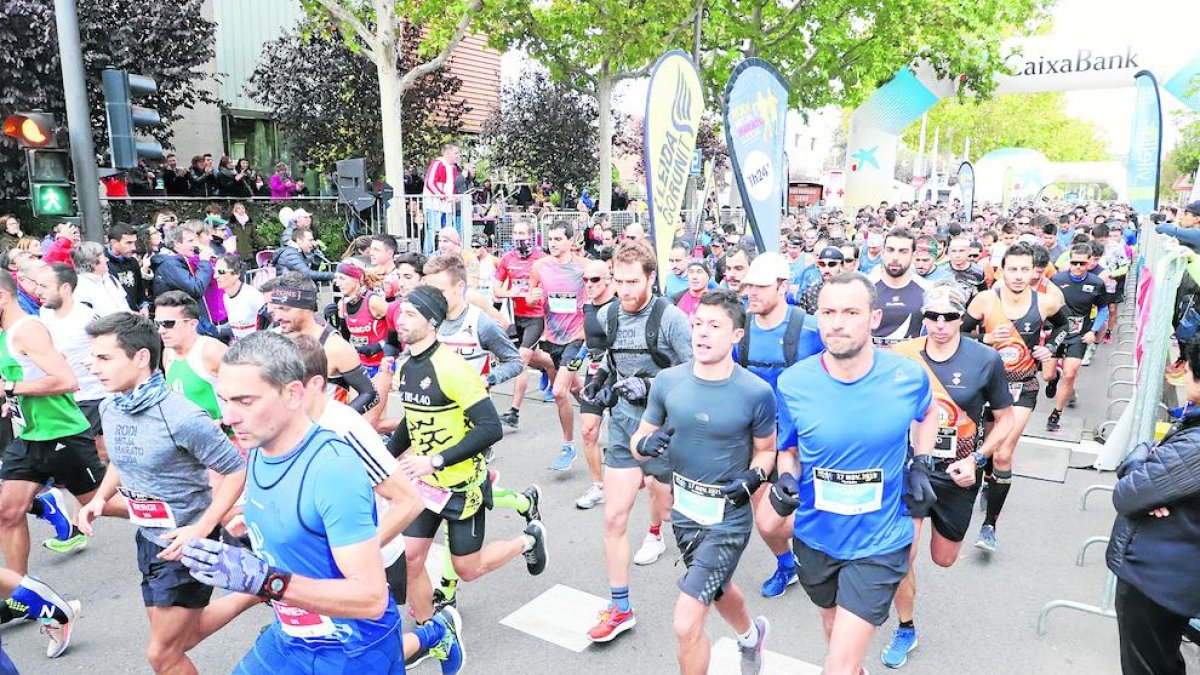 Alguns atletes durant el pas de la Mitja Marató pel pont Vell.