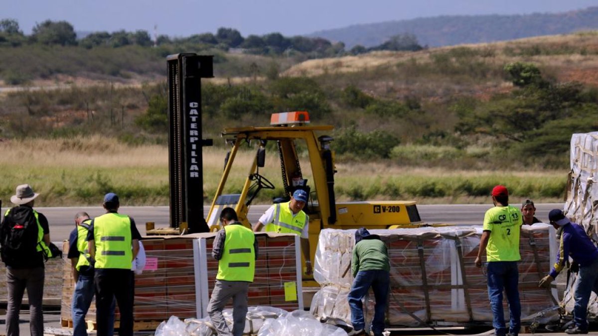 Treballadors descarreguen ajuda humanitària enviada pels EUA a l’aeroport de Cúcuta, Colòmbia.