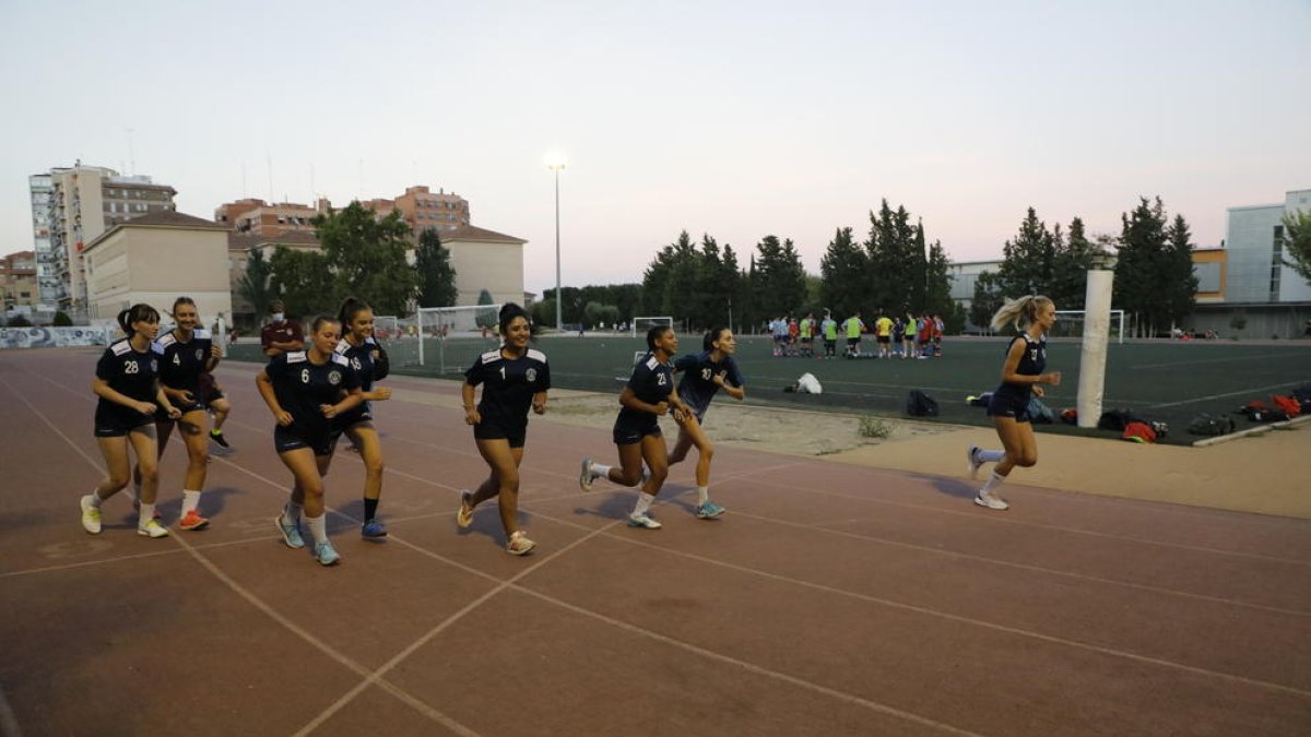 Les jugadores de l’Associació, ahir a la pista del Camp Escolar. Al fons, un equip de futbol.