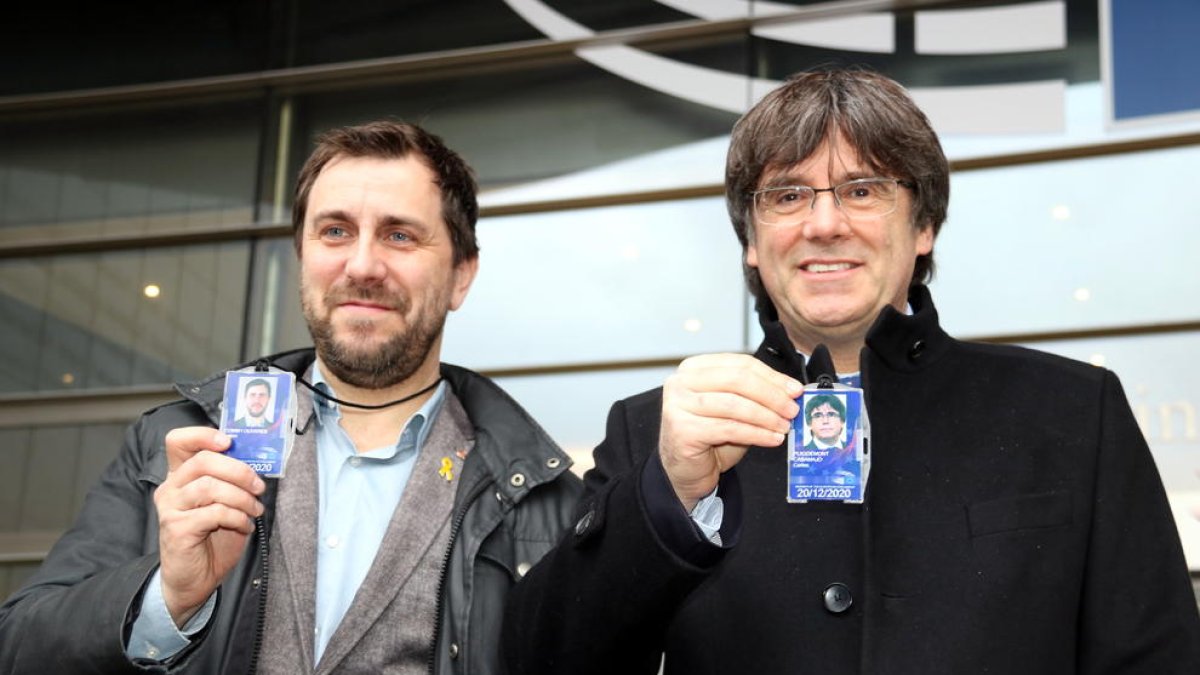 Carles Puigdemont y Toni Comín delante de el Parlamento Europeo en Bruselas con la acreditación como eurodiputados en la mano.