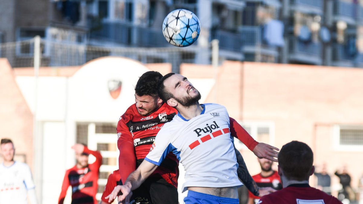 Dos jugadors pugnen per una pilota aèria en una de les jugades del derbi d’ahir.