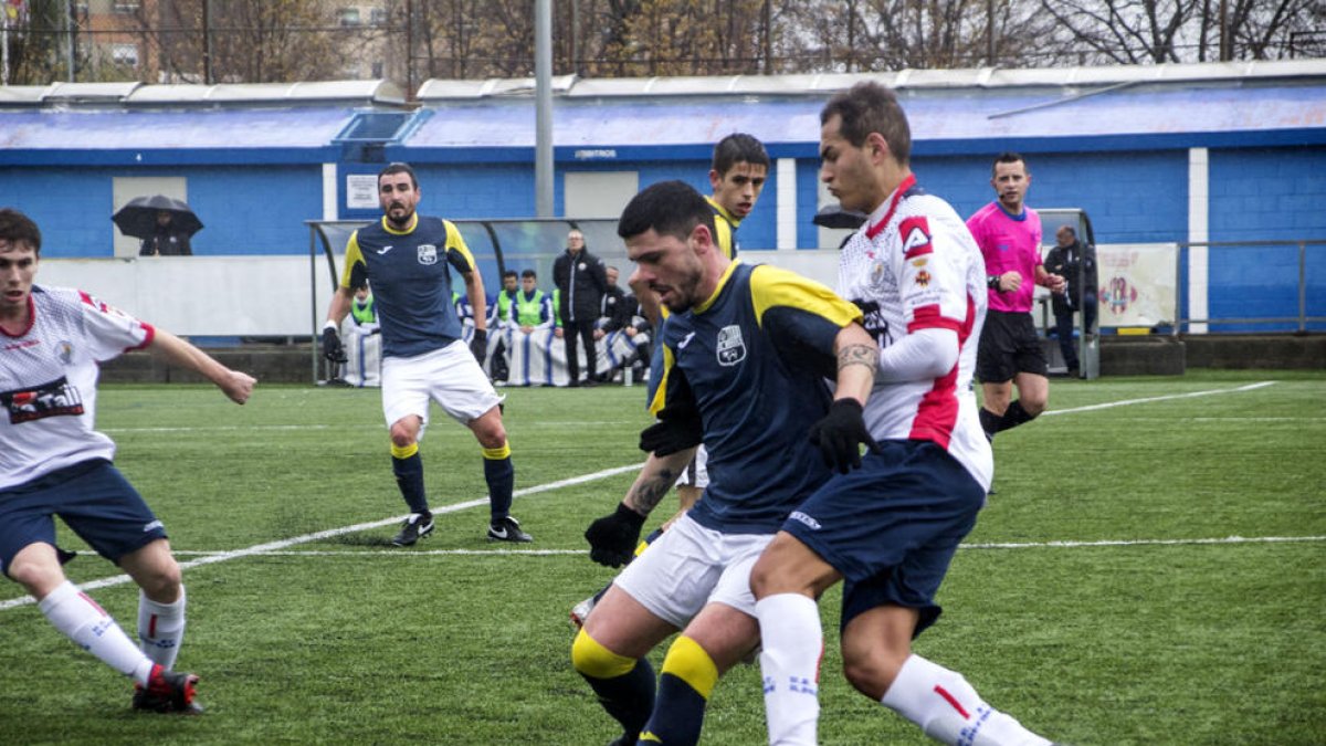 Un jugador del Borges Blanques protegeix la pilota davant la pressió d’un del Sant Ildefons.