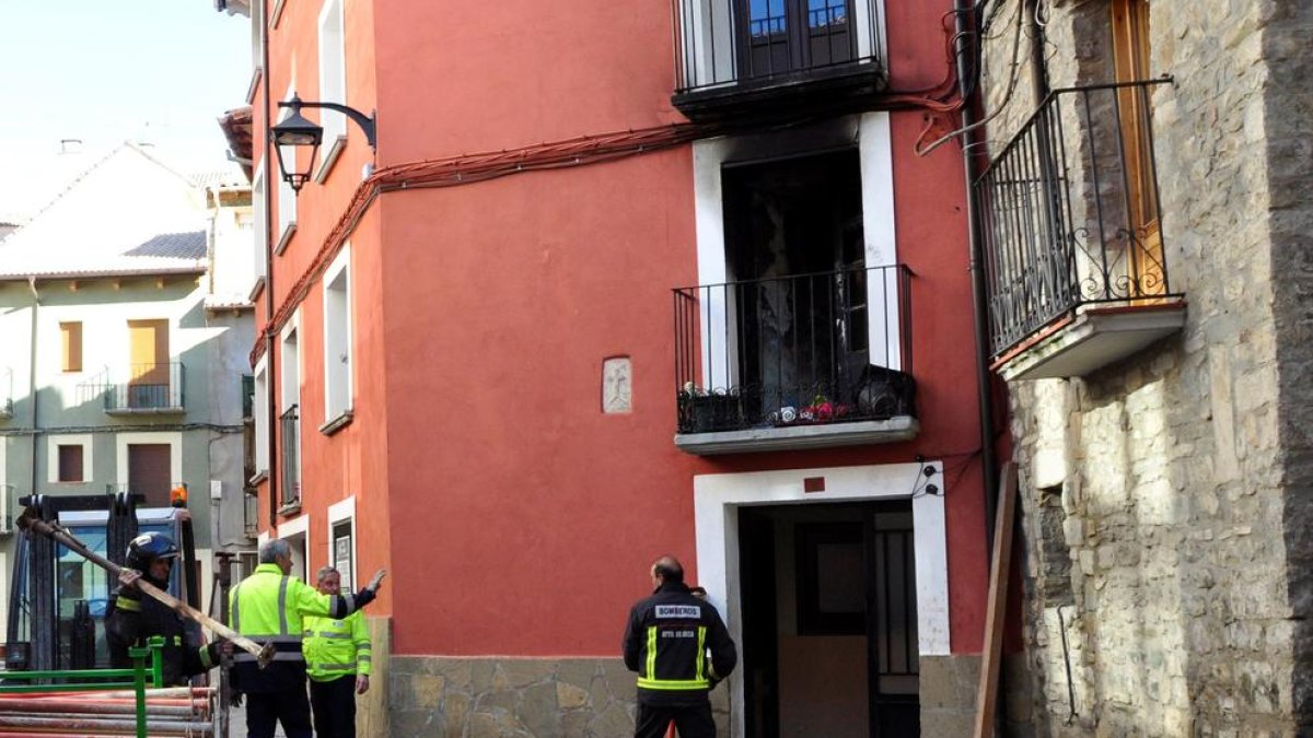 Imagen de bomberos frente al edificio afectado por el fuego, ayer.