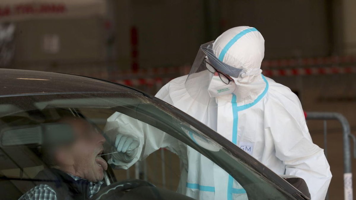 Un professional realitza un test de detecció ràpida a un pacient a Itàlia.