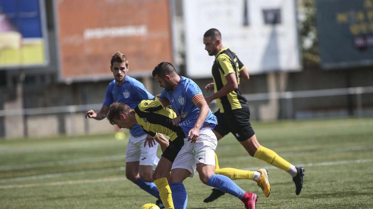 Dos jugadors de l’Alcarràs pressionen un jugador del Muntanyesa durant el partit d’ahir.