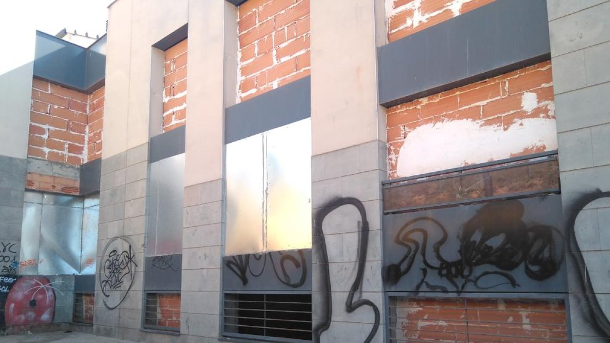 La parte posterior del edificio está tapiada, pero a través de una ventana se puede ver la basura acumulada en el interior (derecha).