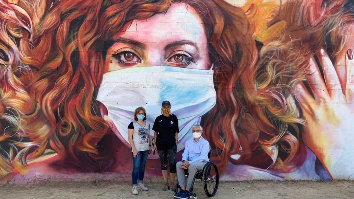 L’artista Lily Brik (centre) davant del seu mural amb l’alcalde, Jordi Latorre, i la regidora Ester Roig.