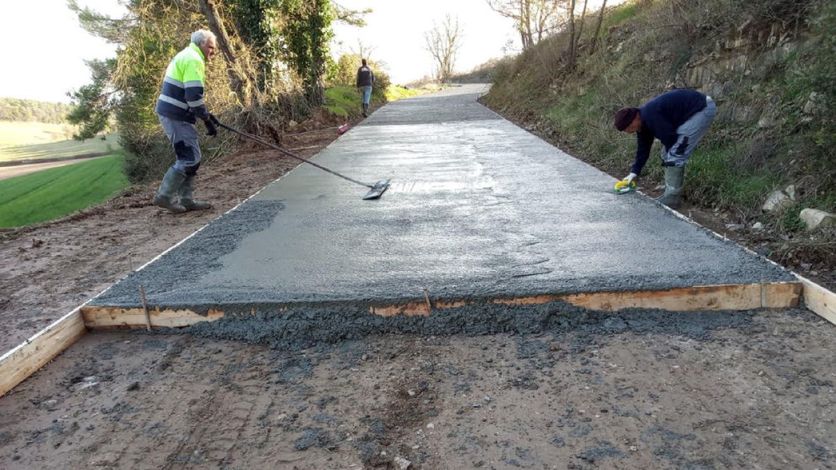 Operaris asfalten un dels camins de Sant Guim de Freixenet.