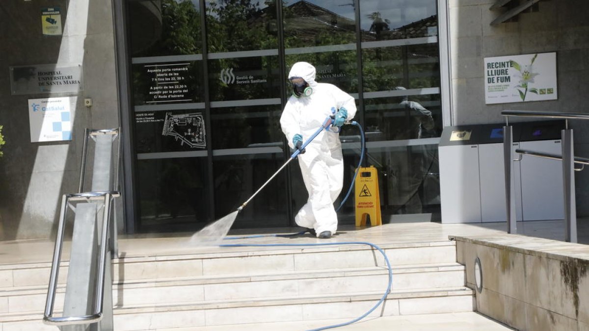 Un operari desinfecta l’entrada de l’hospital Santa Maria.