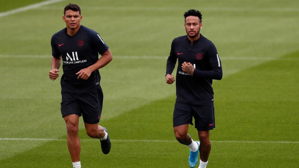 Neymar s’entrena amb el PSG, a la imatge amb Thiago Silva, mentre es resol el seu futur.