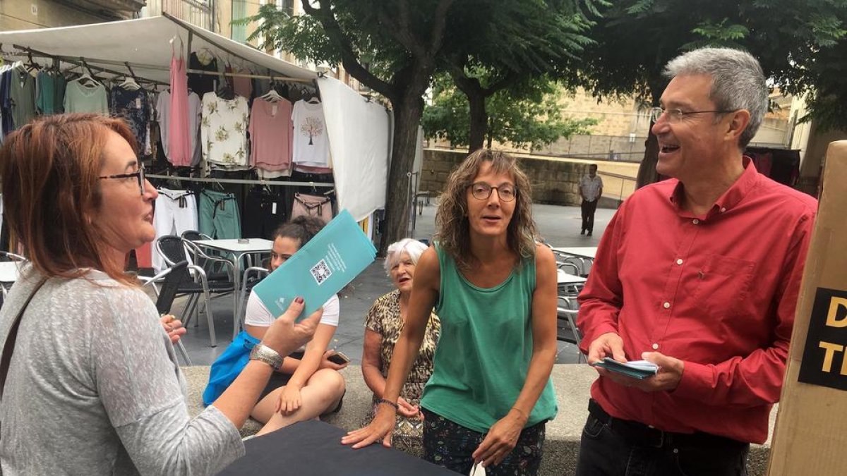 El alcalde de Guissona, Jaume Ars, atendiendo a una vecina en el estand del mercado semanal.