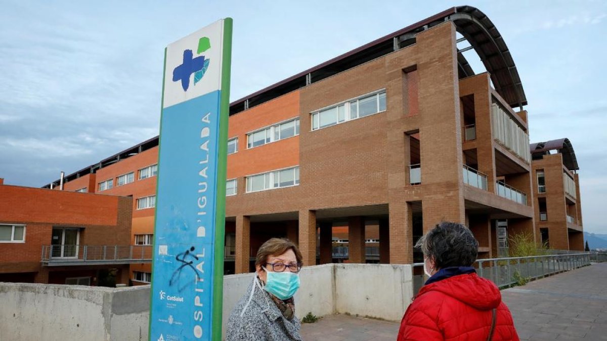 Dos dones amb mascareta davant de l’hospital d’Igualada.