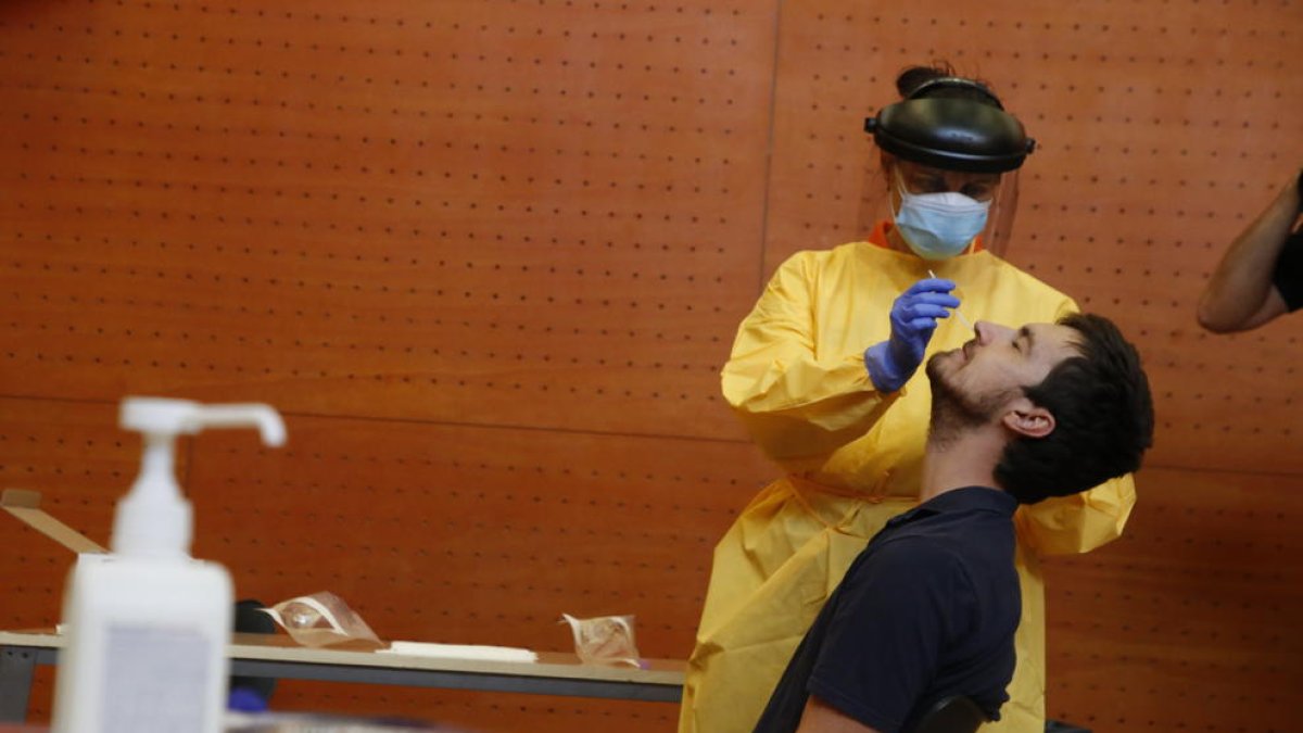 Imatge d’un sanitari fent la PCR a un jove al centre cívic de Balàfia.