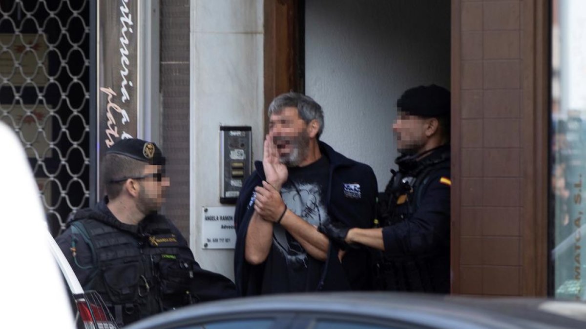 Agentes de la Guardia Civil trasladan a uno de los activistas independentistas arrestados ayer, en Sabadell.