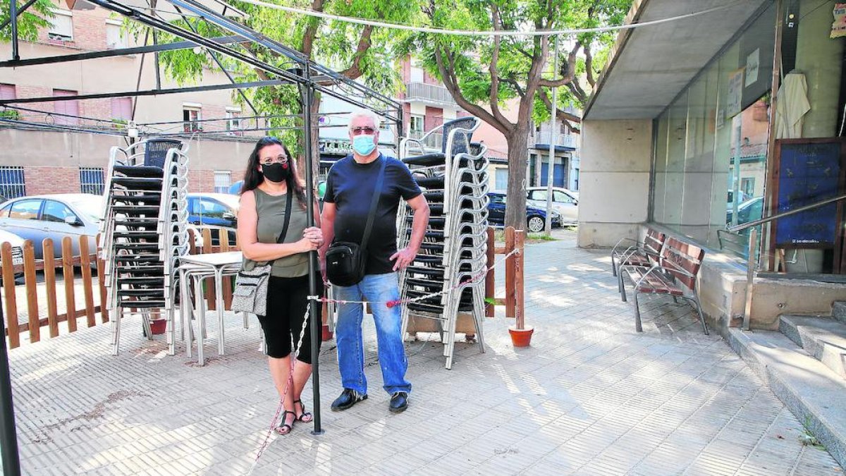 Mónica y Juan, frente a la terraza cerrada del bar del local social de Balàfia que regentan.