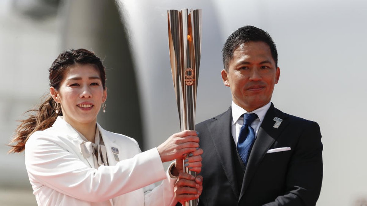 Saori Yoshida i Tadahiro Nomura sostenen la flama olímpica després d’arribar a la ciutat de Matsushima.