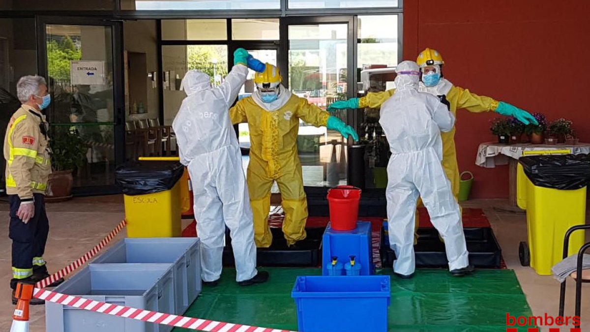 Imatge dels Bombers al col·locar-se els equips de protecció individual.