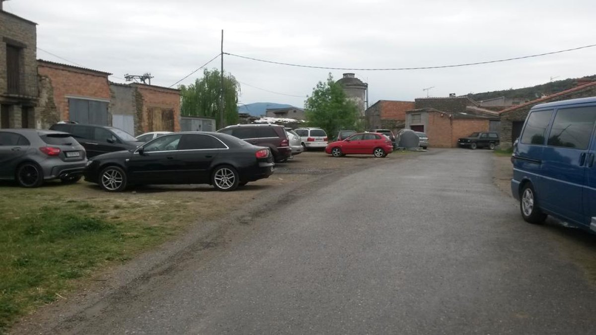 Vehicles estacionats davant de garatges i magatzems de la Règola, on està previst el pàrquing.