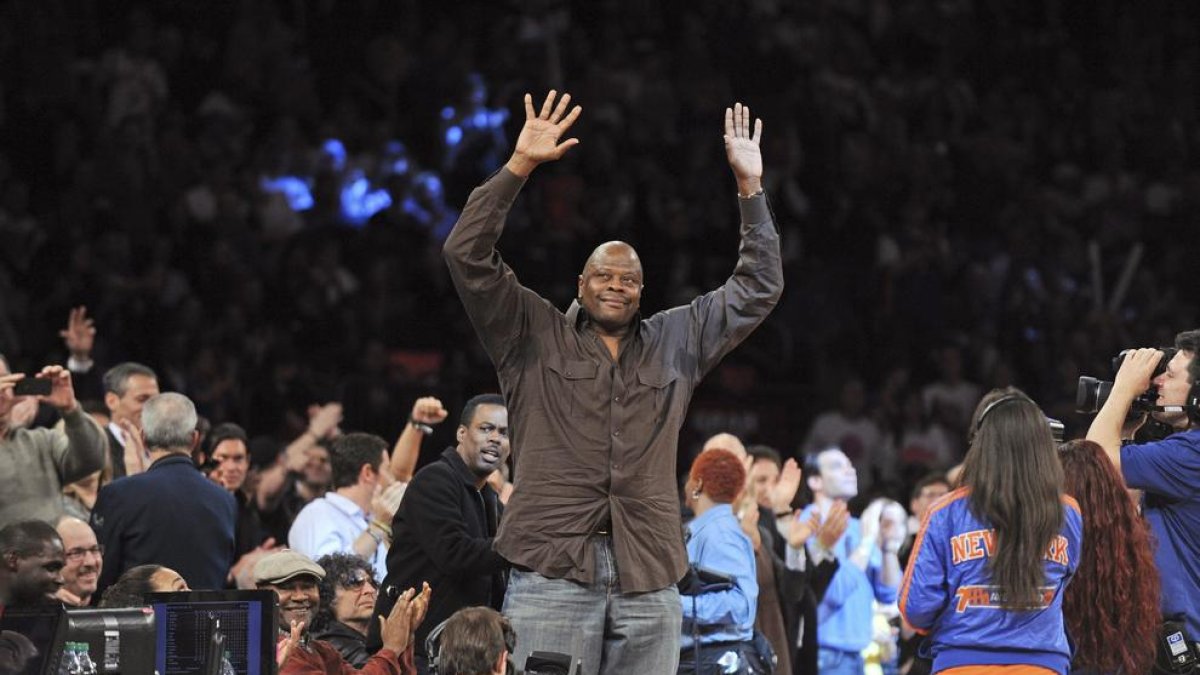 Ewing saluda al público mientras asiste a un partido de la NBA.