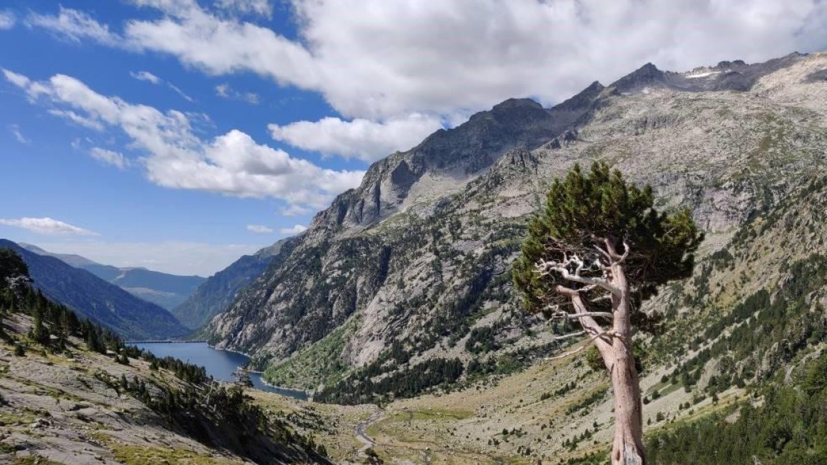 A l’esquerra, estany de Sant Maurici i els Encantats des del mirador de l’estany. A dalt, l’embassament de Cavallers i al costat, la tanca del pàrquing de Cavallers, complet aquesta setmana.