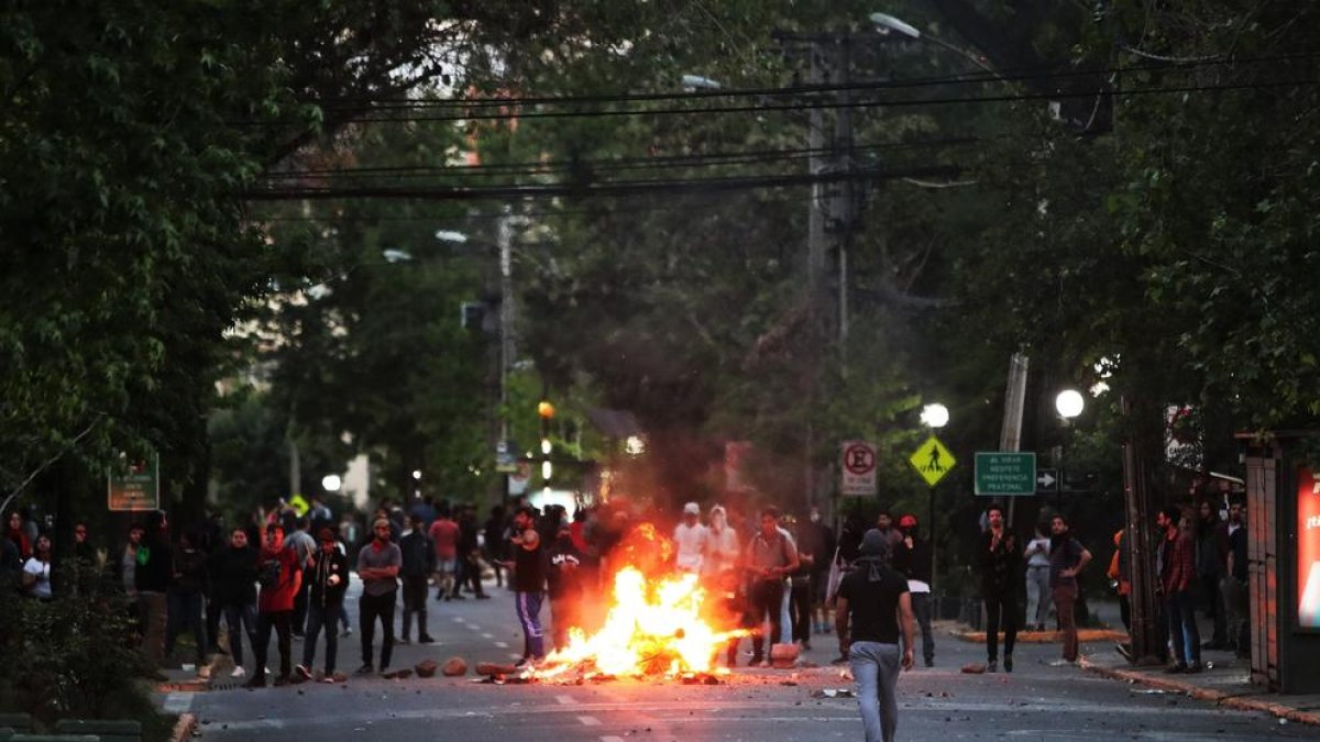 Manifestantes prende fuego a una barricada en una calle del barrio de Providencia, en Santiago.