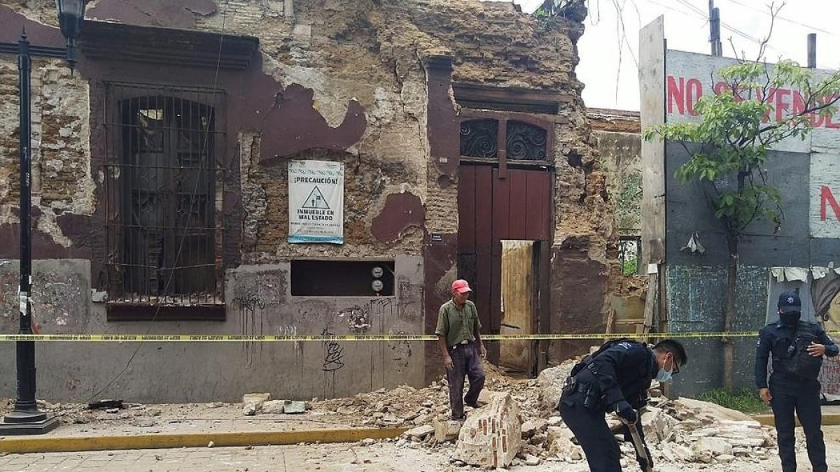 Operaris retiren runa d’un edifici afectat pel sisme.