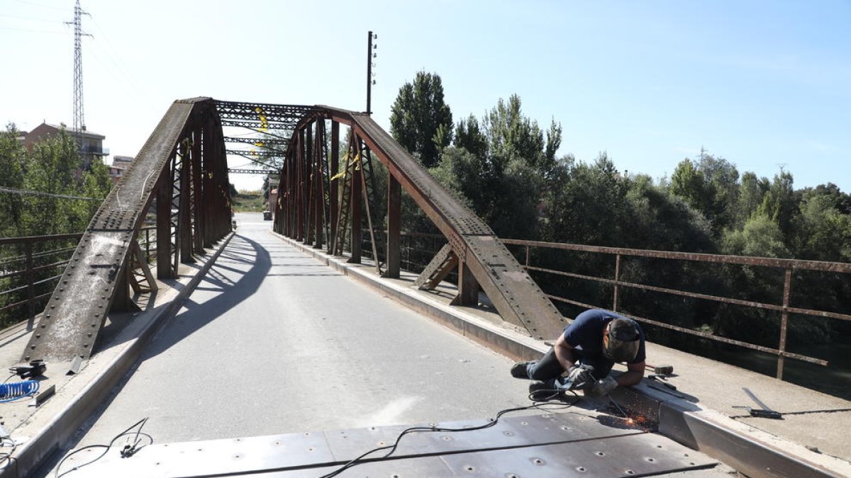 Uno de los operarios trabajó ayer en fijar las nuevas chapas en el firme del puente.