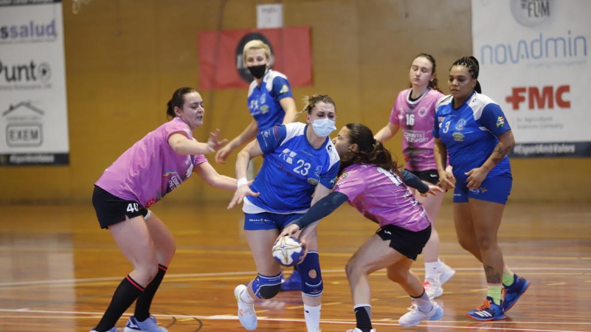 Emma Precup, jugant amb mascareta igual que Pop (darrere), intenta avançar davant la defensa rival.