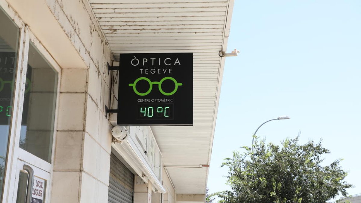 Un joven a la sombra ayer por la tarde en la canalización del río en Lleida.