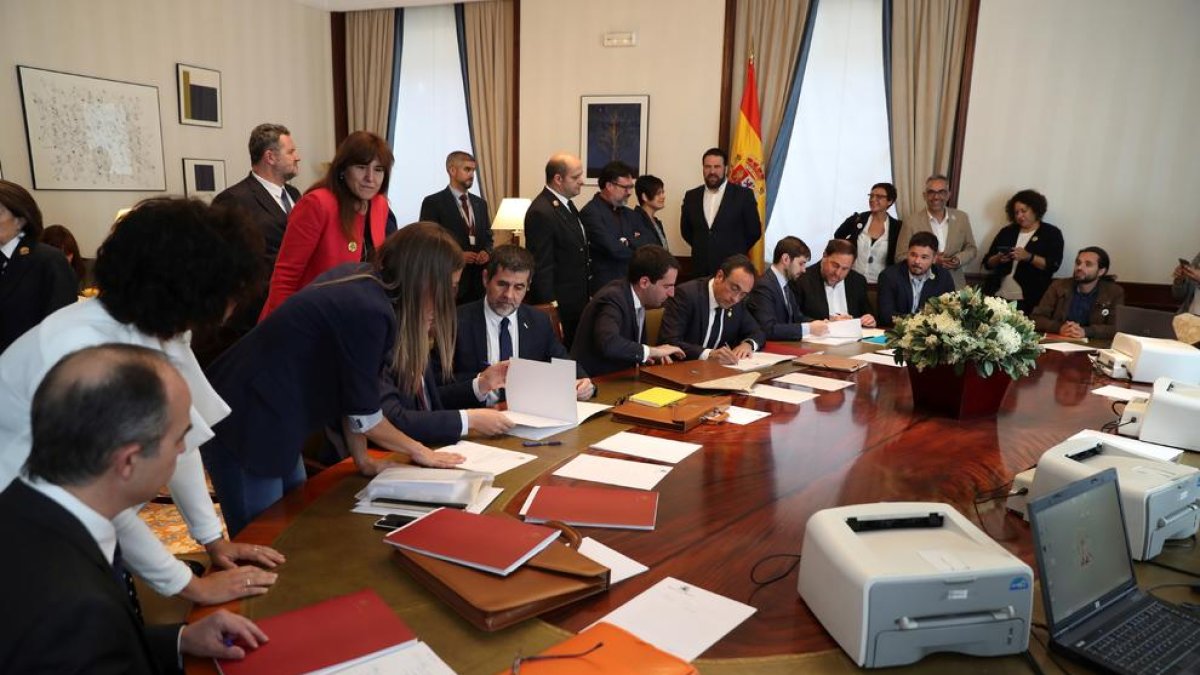 Oriol Junqueras (3d), de ERC, y Jordi Sànchez (4i) y Josep Rull (5d) de JxCat, tramitan sus actas parlamentarias este viernes en el Congreso de los Diputados, previo al acto de constitución de las Cortes que tendrá lugar mañana