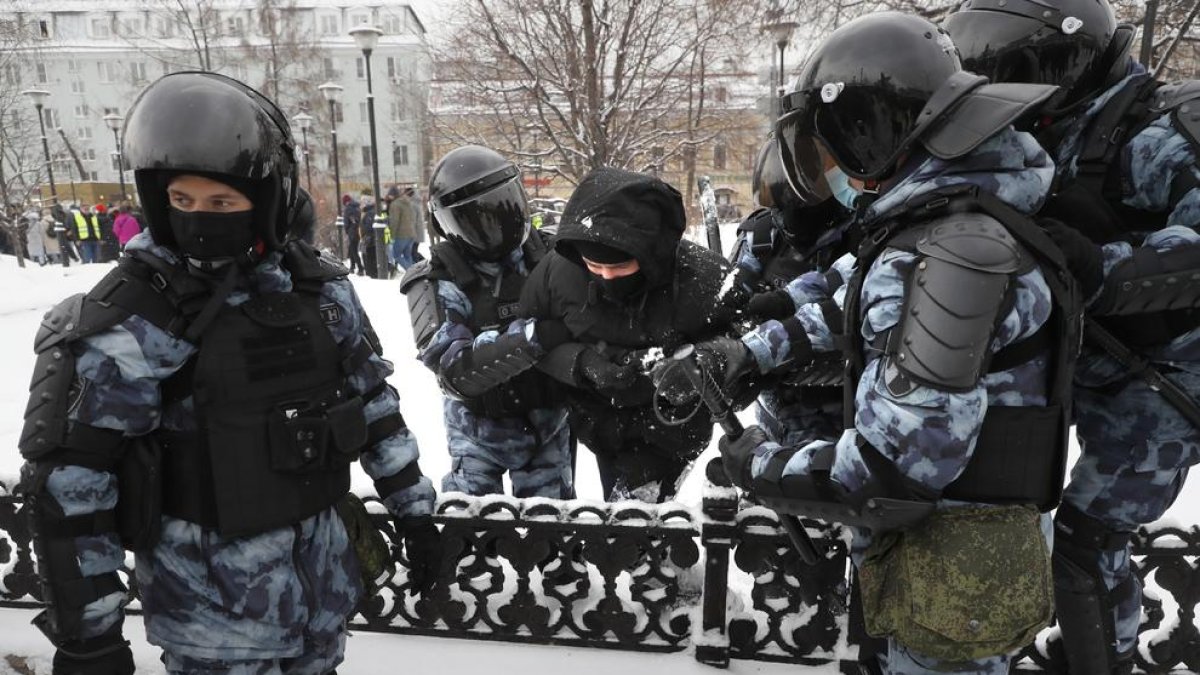 Policías con uno de los manifestantes que fue detenido ayer durante las protetas.