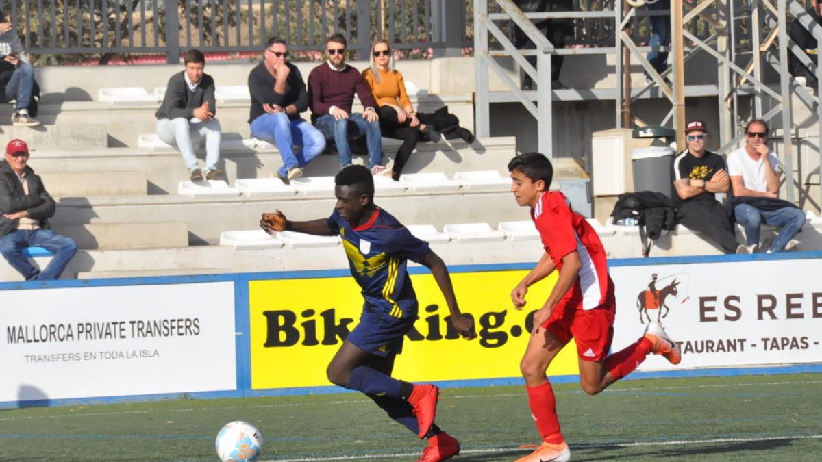 Ousmane Doumbia, de l’Atlètic Segre, perseguit per un rival de la selecció de les Balears.