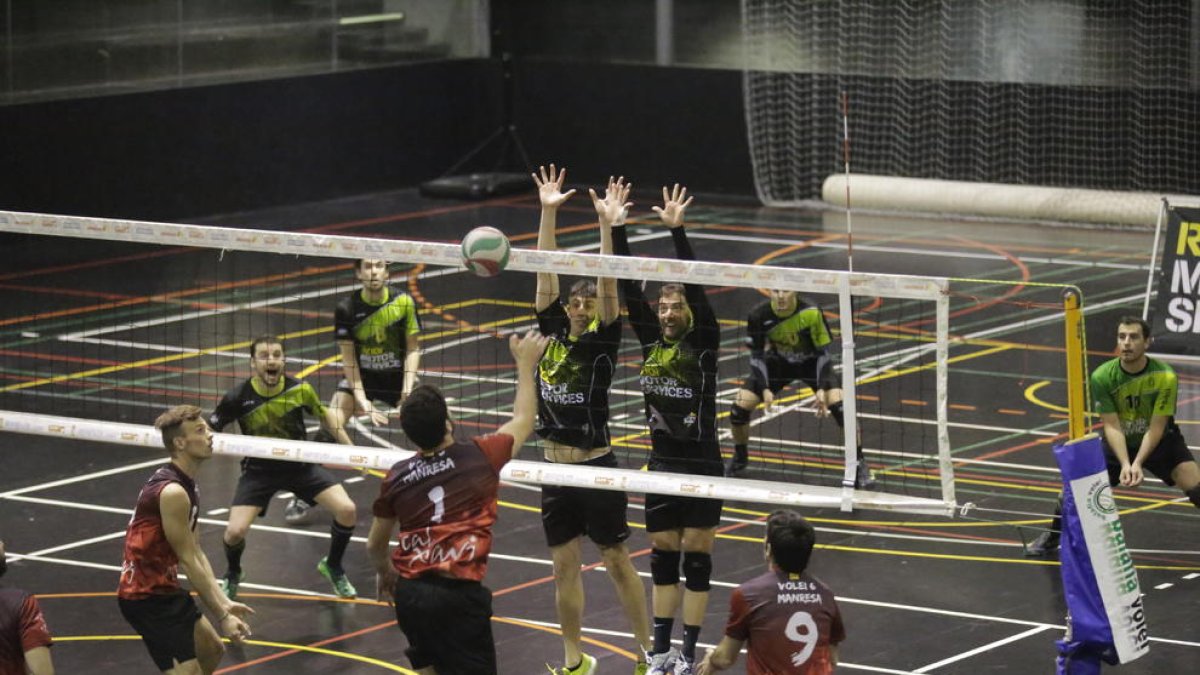 Dos jugadores del Balàfia intentan bloquear el remate de un contrincante del Manresa.