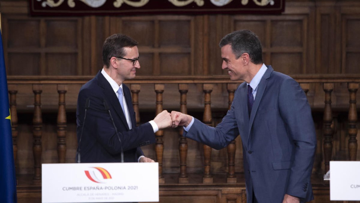 Sánchez se saluda con un choque de puños con el primer ministro polaco al inicio de la rueda de prensa.