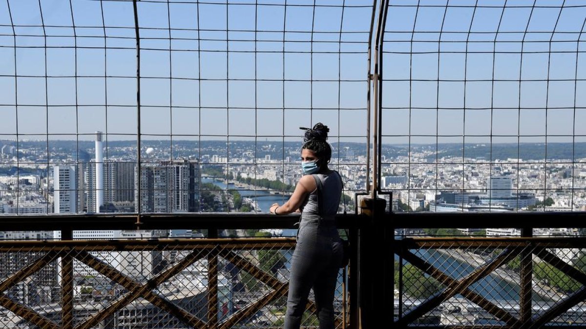 Una visitant de la Torre Eiffel, ahir, amb la ciutat de París de fons.