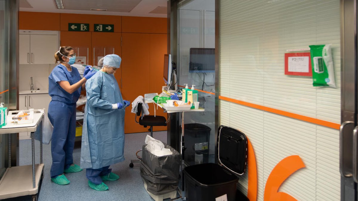 Una professional sanitària es protegeix abans d'entrar en una habitació d'un positiu per coronavirus a l'Hospital Clínic