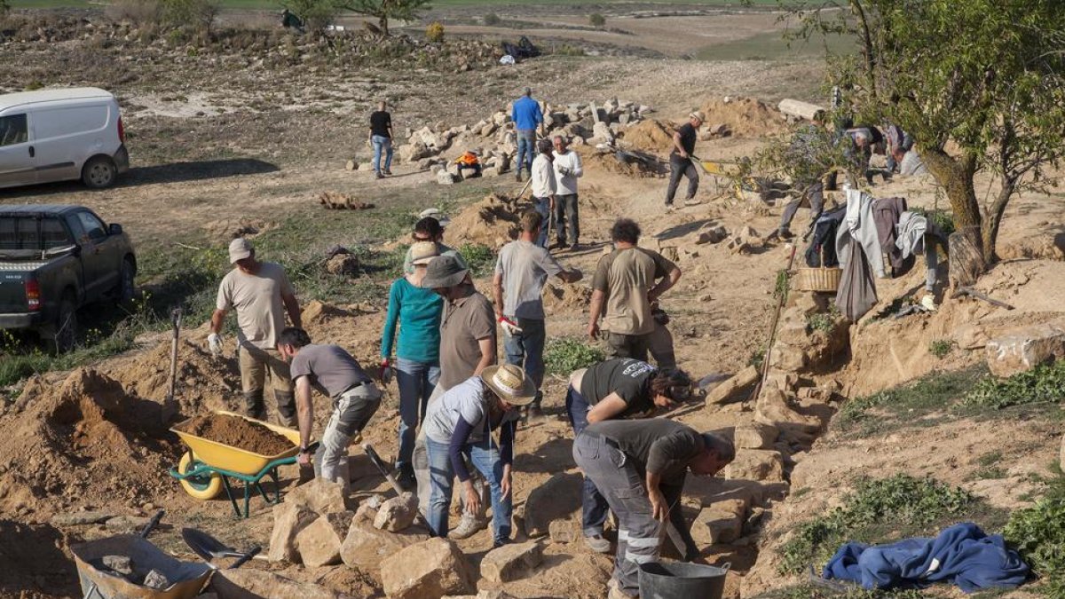Voluntarios trabajando ayer en la conservación de márgenes de piedra seca en Castellserà.