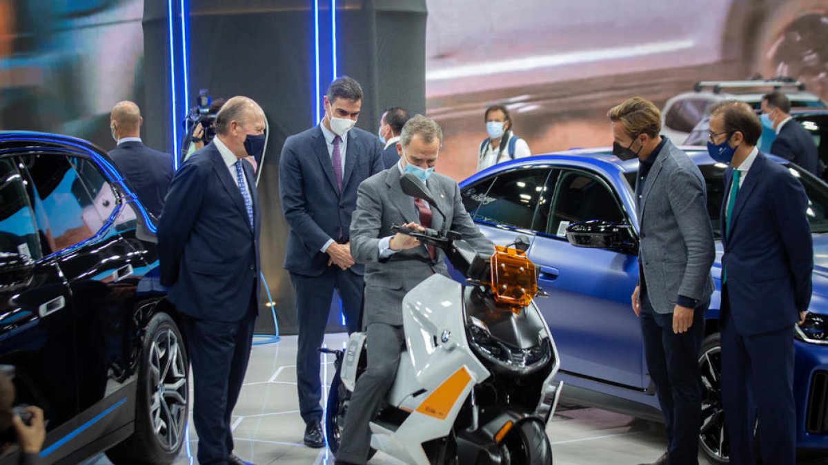 El rei muntat sobre una moto al costat de Sánchez durant el seu recorregut, ahir, pels expositors.