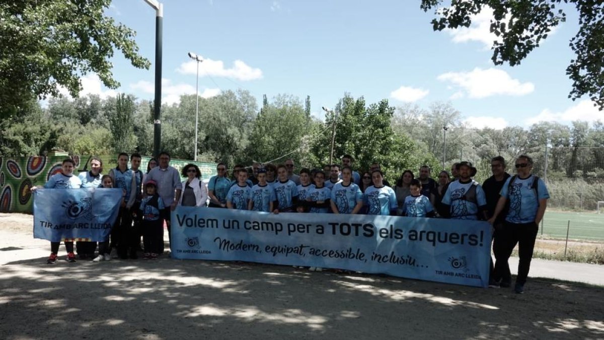 Arqueros y directivos del Club Tir amb Arc Lleida, junto con la pancarta que exhibieron para reclamar un lugar donde entrenar.