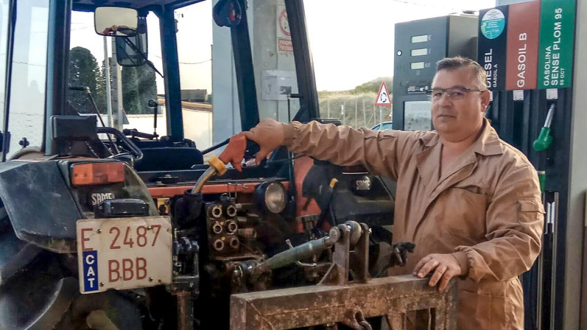 Josep Lluís Escuer, en una imatge d’arxiu, reposta el tractor.